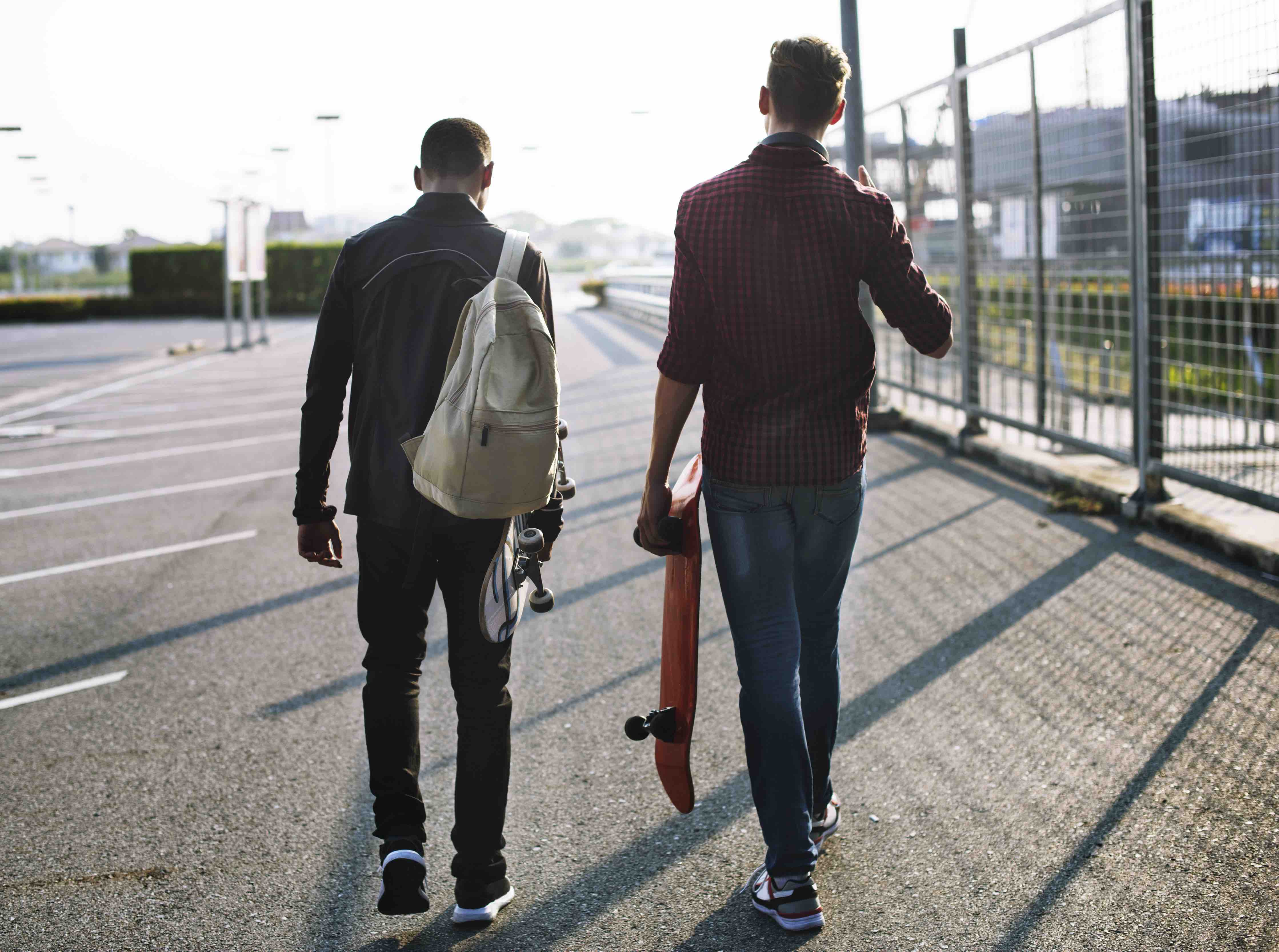 Two teenager boys walking with skateboards