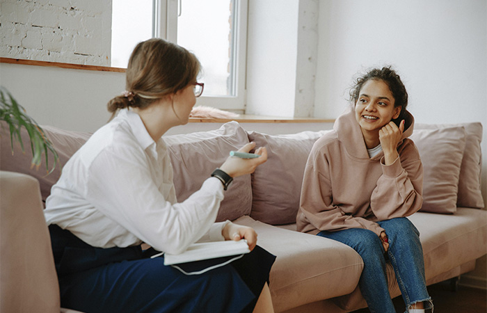 Young woman talking with her therapist, represents the path to becoming a therapist by Jessica Krock.