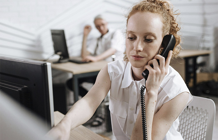 Woman taking a call, representing the volunteer work before becoming a therapist. 